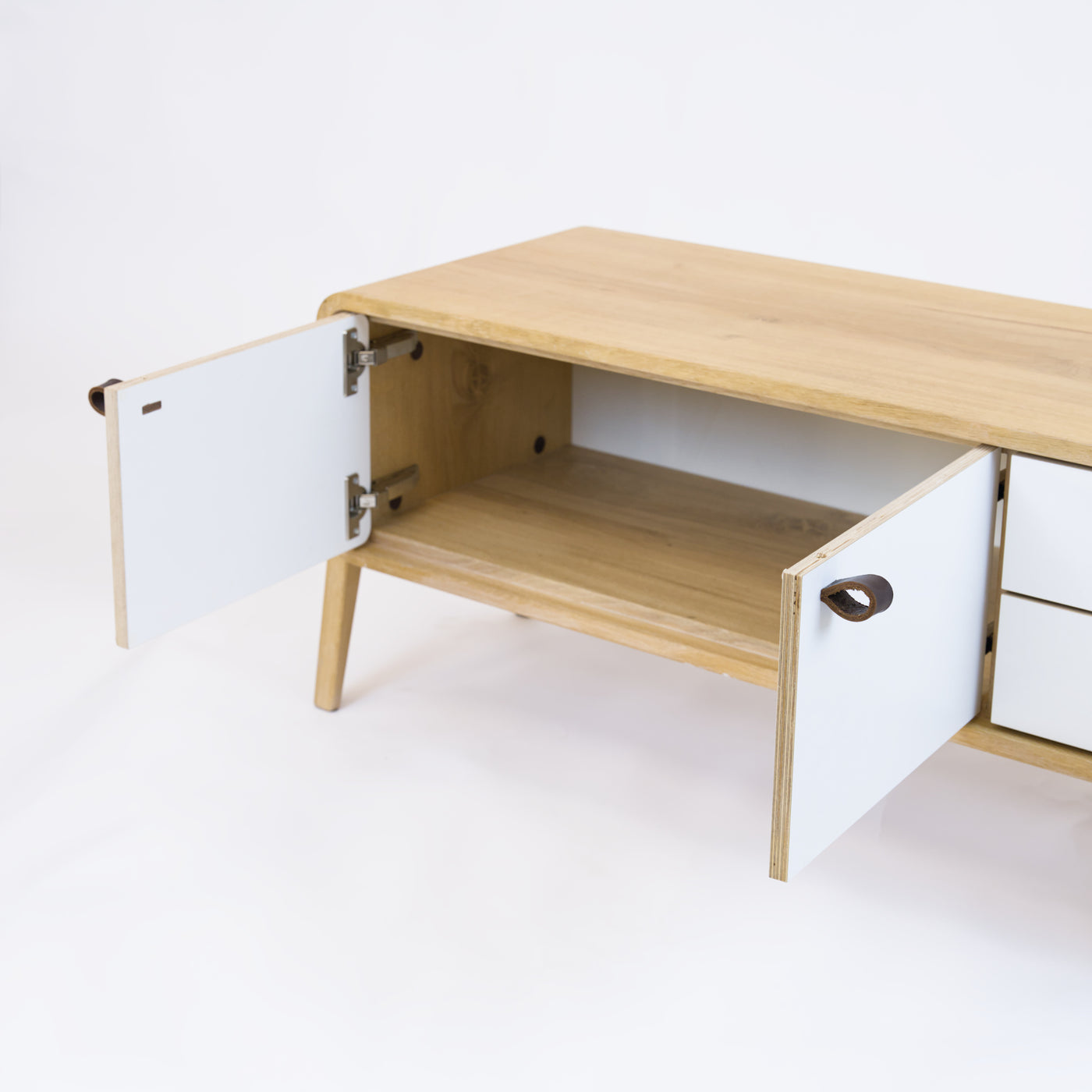 Low sideboard nm23L. The main corpus is crafted from solid Norwegian oak, featuring 2 doors and 2 right drawers, all with white fronts.